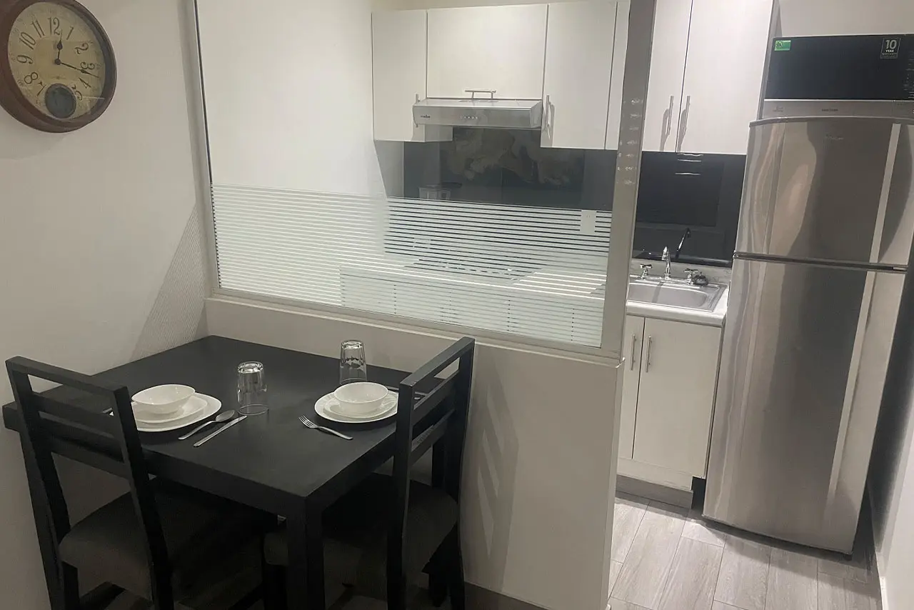 cocina con refrigerador y microondas con mesa de la suite de 1 recámara